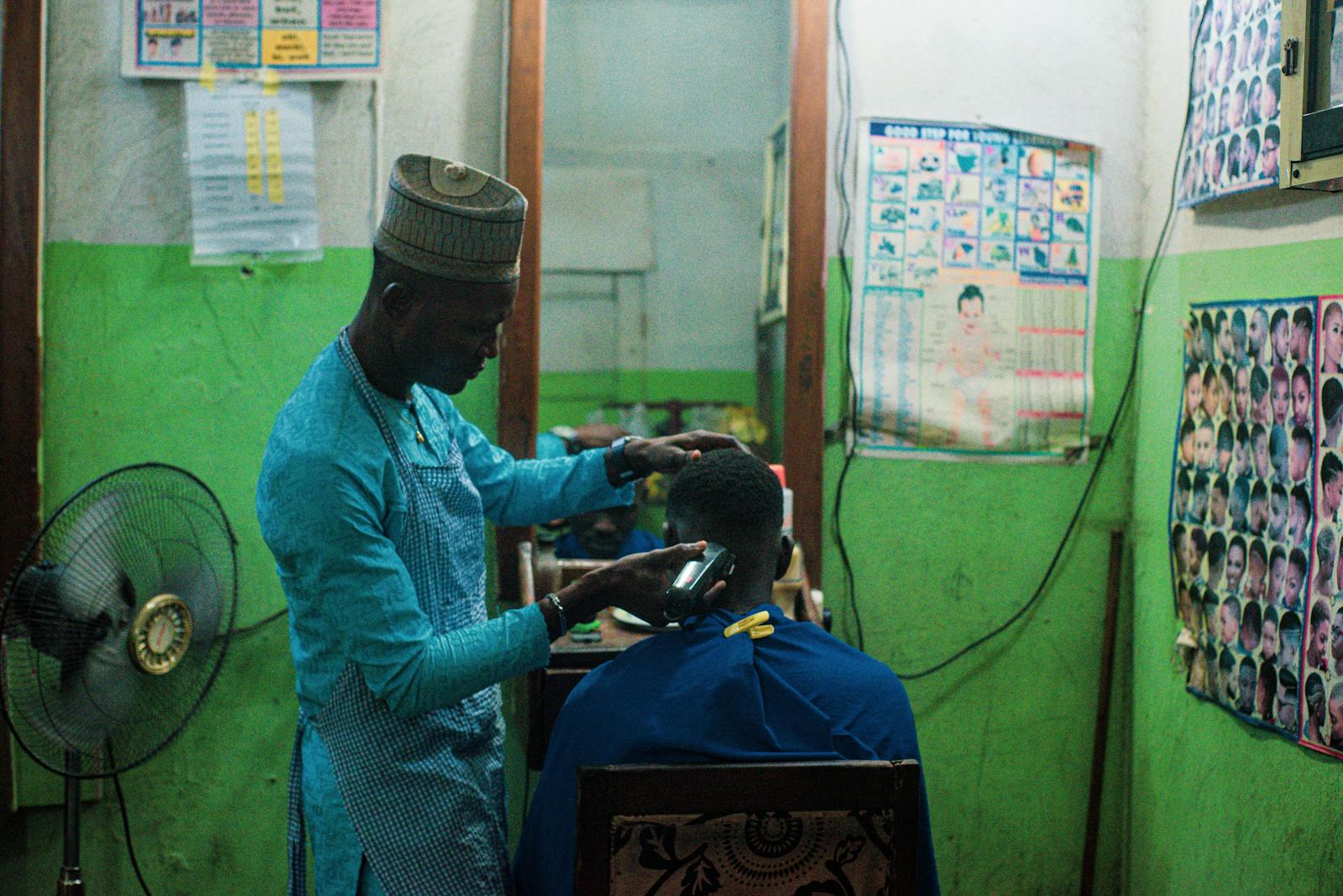 A barber cutting hair in a small neighborhood shop
